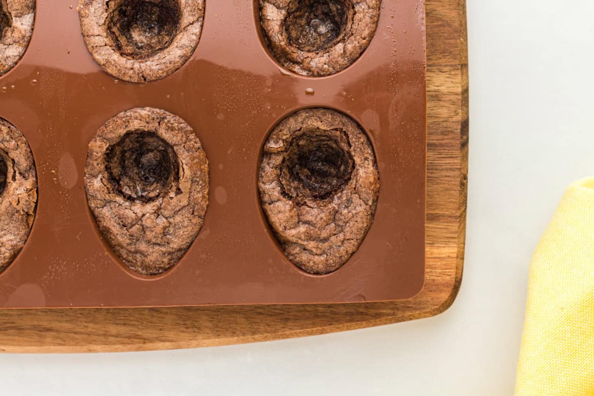 closeup of baked brownies with a yolk-shaped circle scooped out of the center in a silicone mold.
