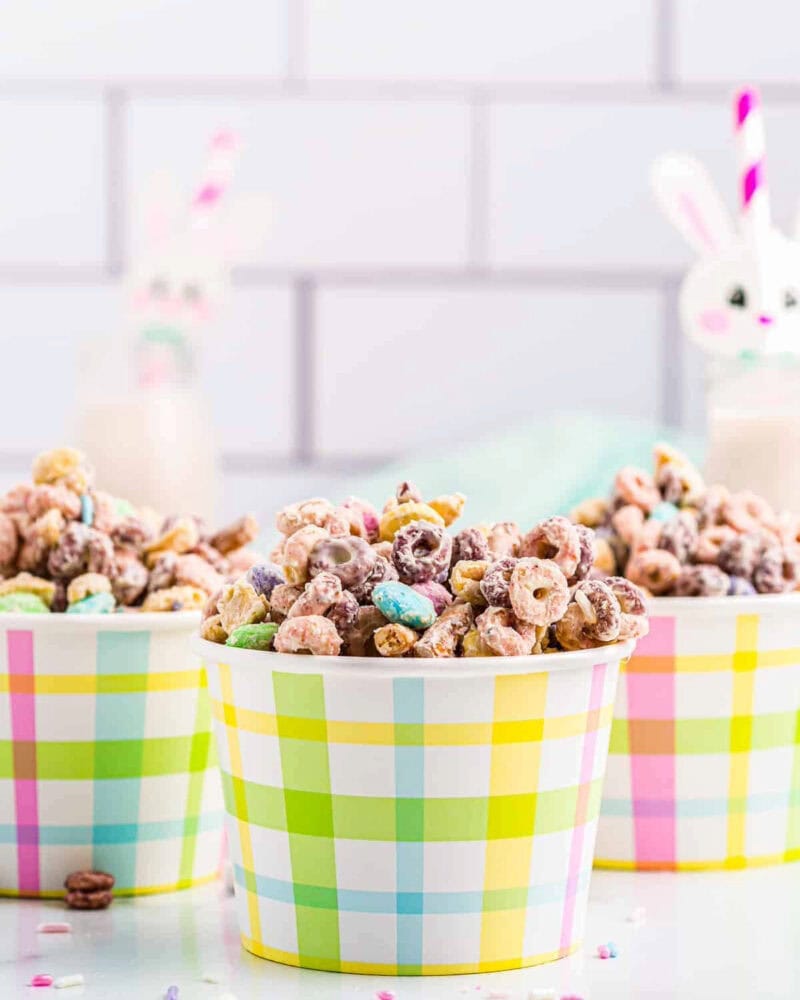 Three plaid cups filled with bunny bait snack mix.