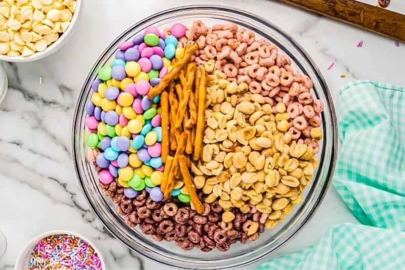 Easter snack mix ingredients combined in a bowl.