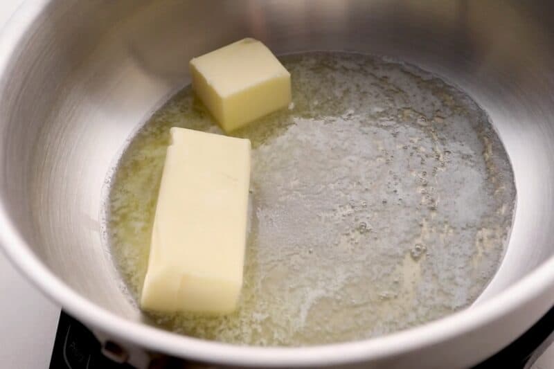 Sticks of butter melting in a pan.