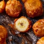 Fried bananas with a crispy batter, with one cut in half.
