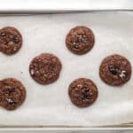 Baked cookies on a lined baking sheet.
