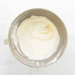 Whipped heavy cream in a silver bowl.