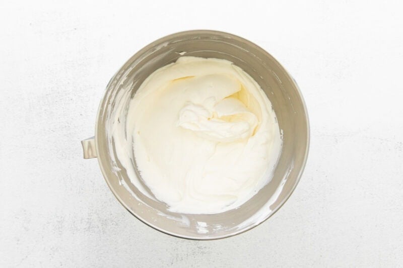 Whipped heavy cream in a silver bowl.