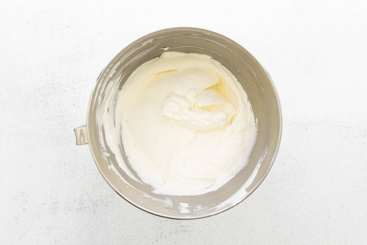 Whipped heavy cream in a silver bowl.