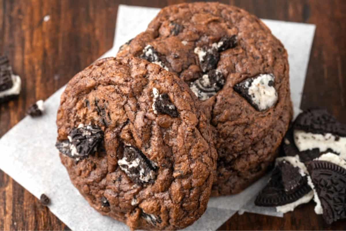 Brownie mix cookies stuffed with Oreos, on a wooden table.