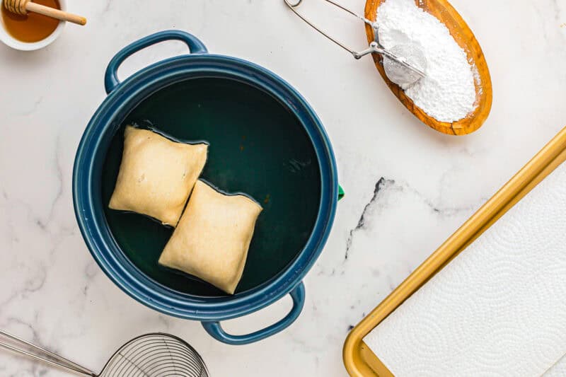 Frying the sopapillas in oil.