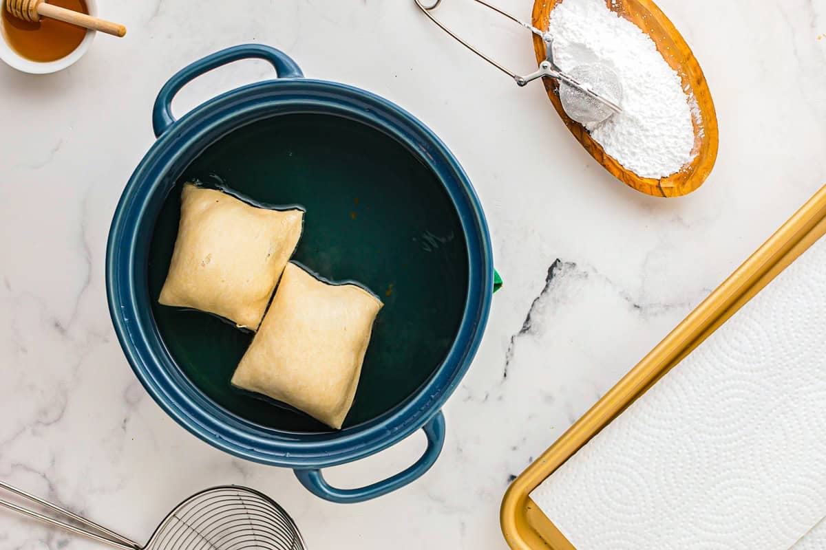 Frying the sopapillas in oil.