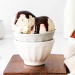 Ice cream with chocolate sauce on top served in a bowl.