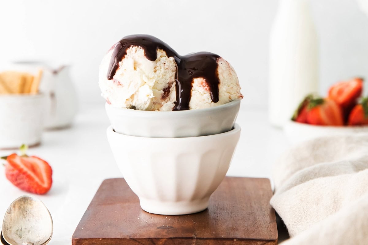 Ice cream with chocolate sauce on top served in a bowl.