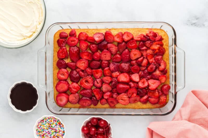 Sliced strawberries on top of the cake.