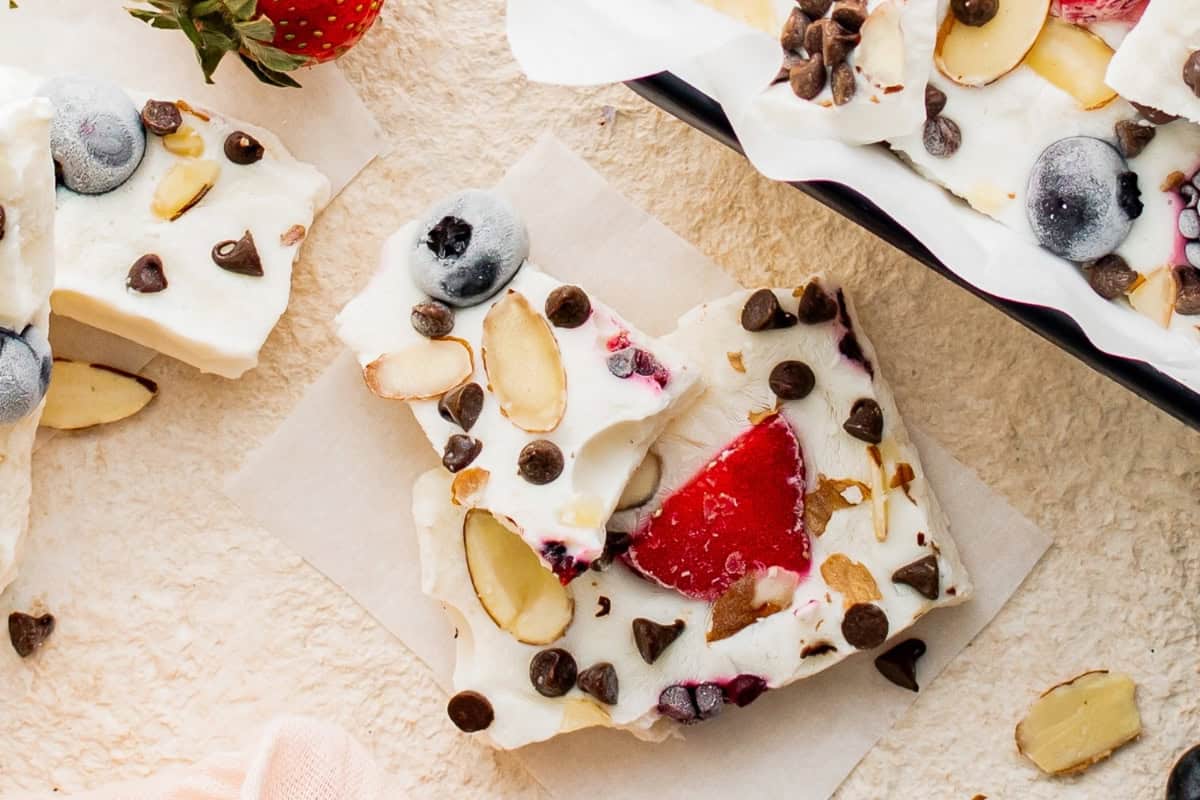 Two pieces of frozen Greek yogurt fruit bark stacked on top of each other.