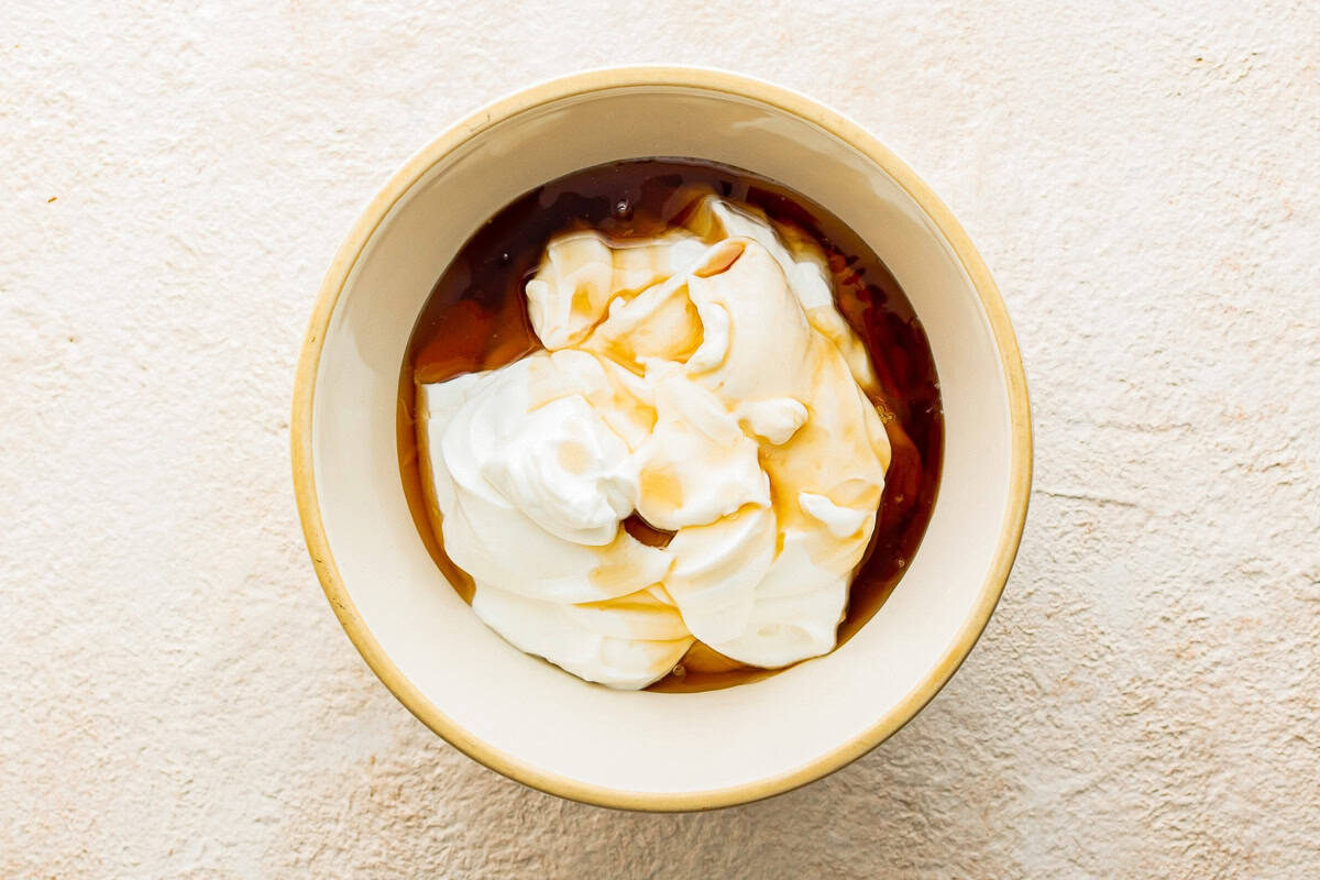 Greek yogurt, maple syrup, and vanilla in a mixing bowl.