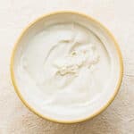 Yogurt, maple syrup and vanilla whisked together in a bowl.