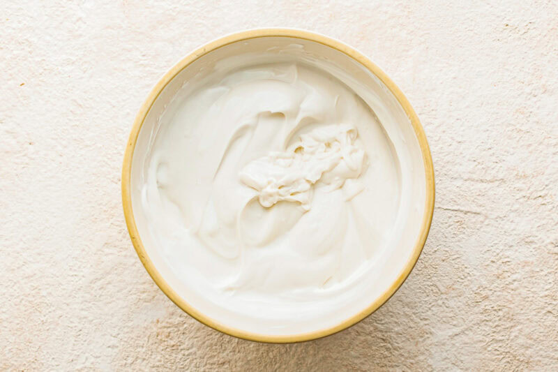 Yogurt, maple syrup and vanilla whisked together in a bowl.