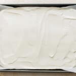 Yogurt mixture spread in the baking tin.