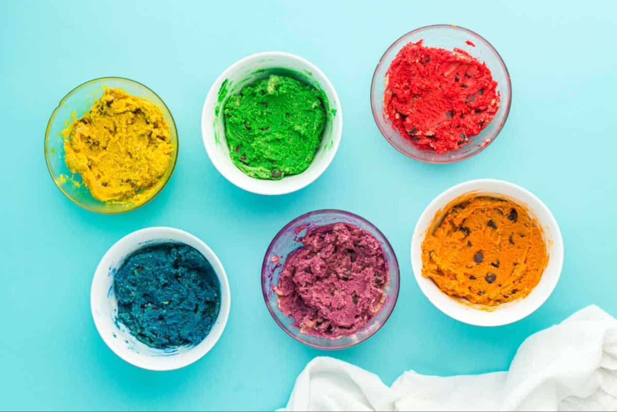 Bowls of chocolate chip cookie dough dyed a range of rainbow colors.