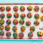 Cookie dough rolled into balls with chocolate chips placed on top.