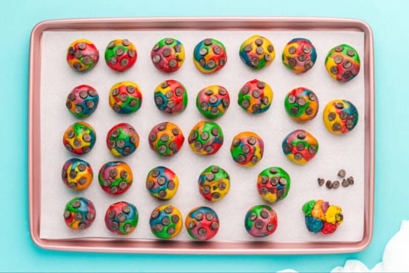Cookie dough rolled into balls with chocolate chips placed on top.