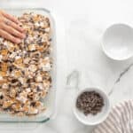 Patting down Golden Grahams marshmallow mixture into baking dish.