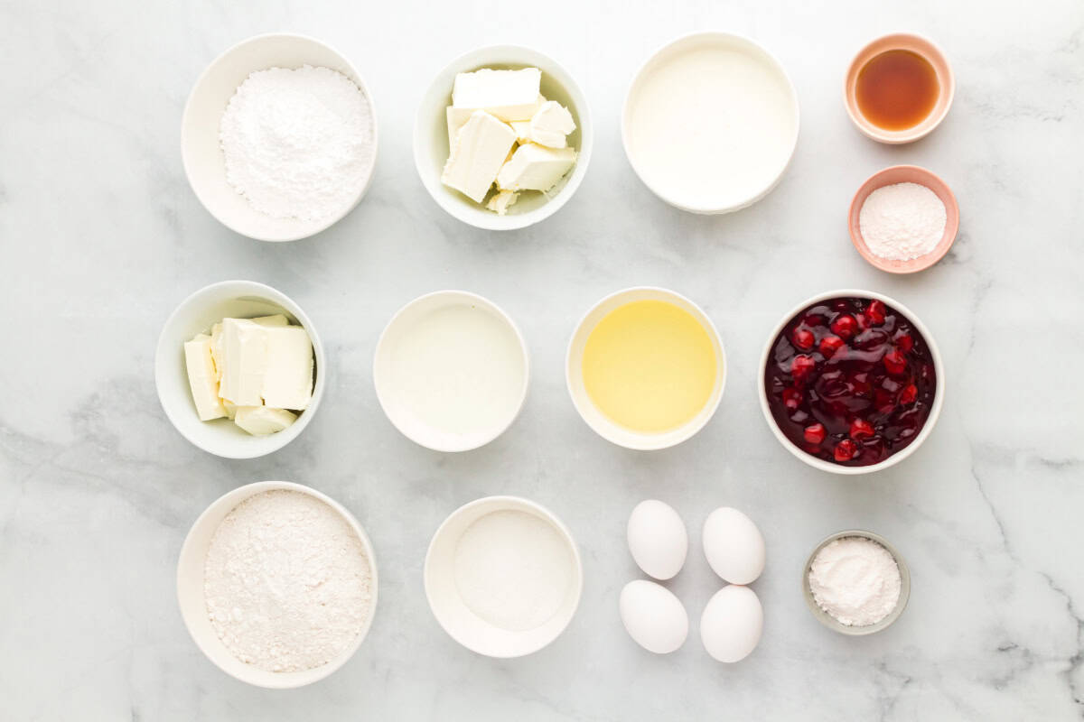 Ingredients for cherry cheesecake cake include cream cheese, milk, vegetable oil, eggs, white cake mix, granulated sugar, Jell-O Instant Cheesecake Pudding Mix, confectioners' sugar, heavy cream, vanilla extract, and cherry pie filling.