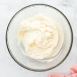 Cream cheese frosting in a glass mixing bowl.
