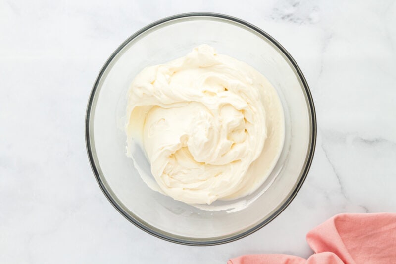 Cream cheese frosting in a glass mixing bowl.