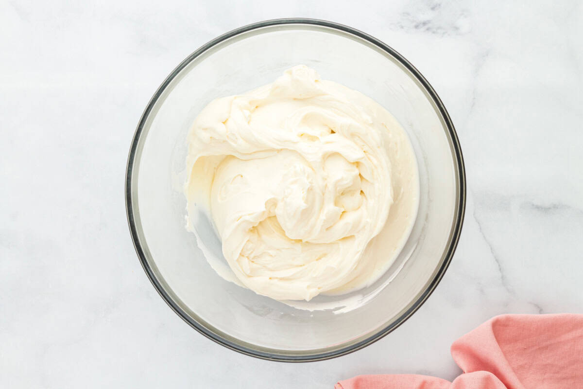 Cream cheese frosting in a glass mixing bowl.