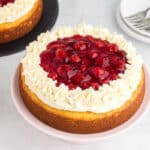 Cherry cheesecake cake topped with cream cheese frosting and cherry pie filling.