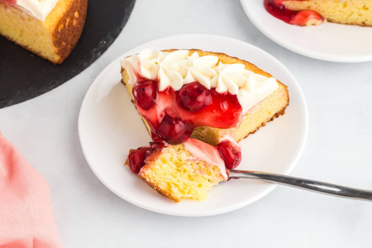 A slice of cherry cheesecake cake.