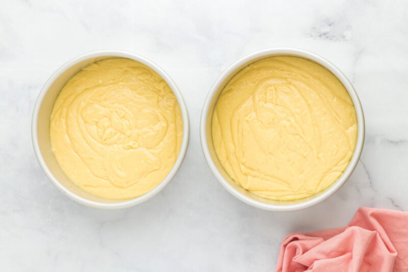 Cherry cheesecake cake batter in two cake pans.