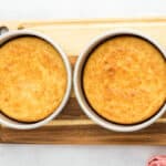 Two cherry cheesecake cakes in cake pans fresh out of the oven.