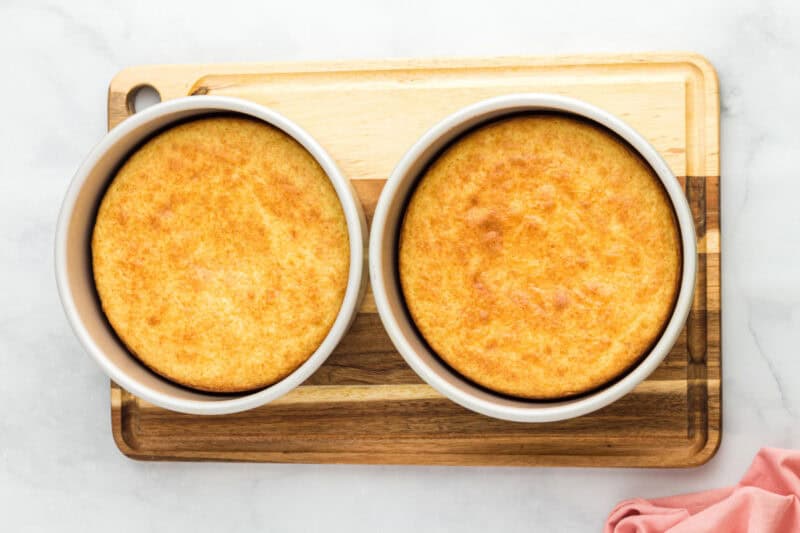 Two cherry cheesecake cakes in cake pans fresh out of the oven.