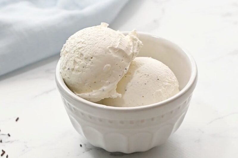 Scoops of no churn vanilla ice cream in a serving bowl.