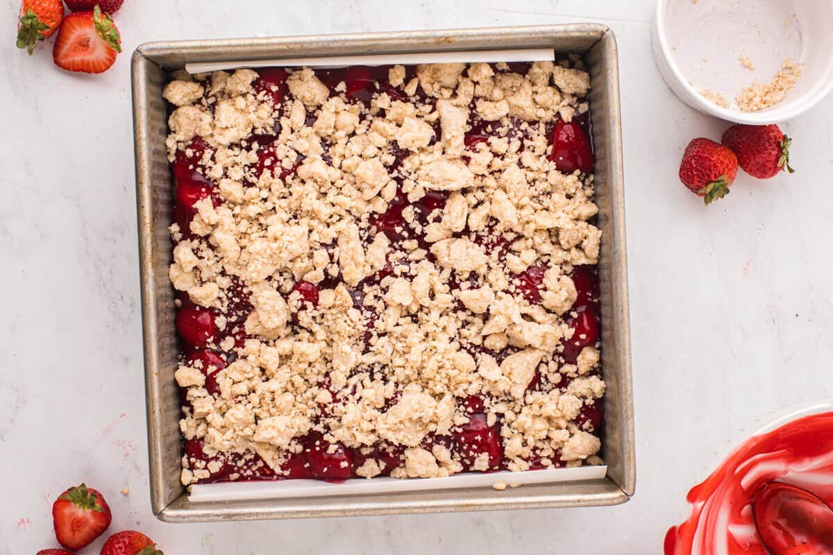 Assembled strawberry crumble bars in a square baking pan.