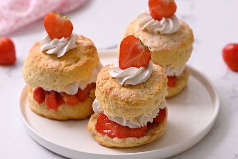 Assembled strawberry shortcake biscuits on a plate.