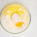 Funfetti cake mix, melted butter, egg, and heavy cream in a glass mixing bowl.