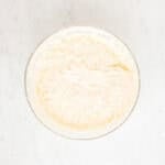 Fluffy cream cheese frosting in a glass mixing bowl.