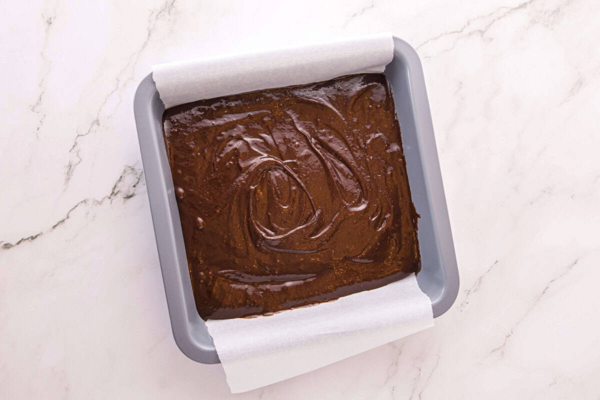 Brownie batter in a 9x9 baking dish.