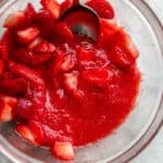 Pureed strawberries and sliced strawberries in a bowl.