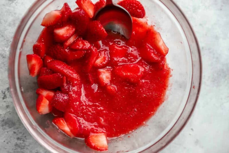 Pureed strawberries and sliced strawberries in a bowl.