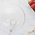 Whisking dry ingredients together in a glass mixing bowl.