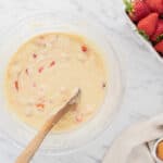 Strawberry muffin batter in a glass mixing bowl.