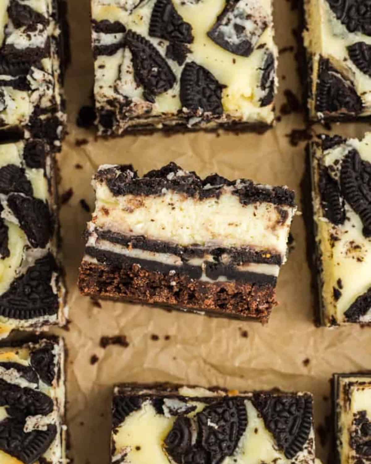 Oreo cheesecake bars, laid on the side to show layers of chocolate cookie crust, Oreos, and cheesecake.