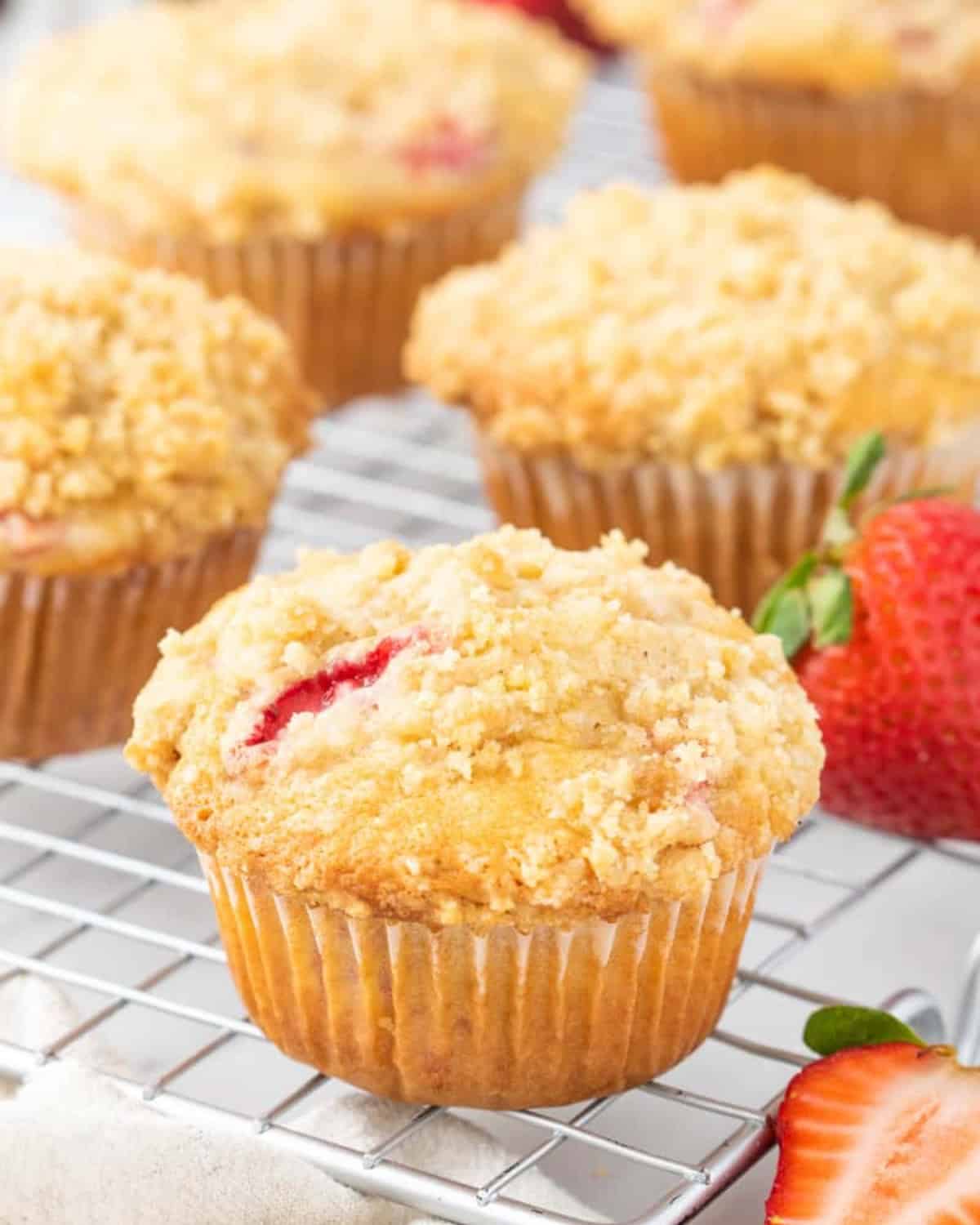 Homemade strawberry streusel muffins on a cooling rack.