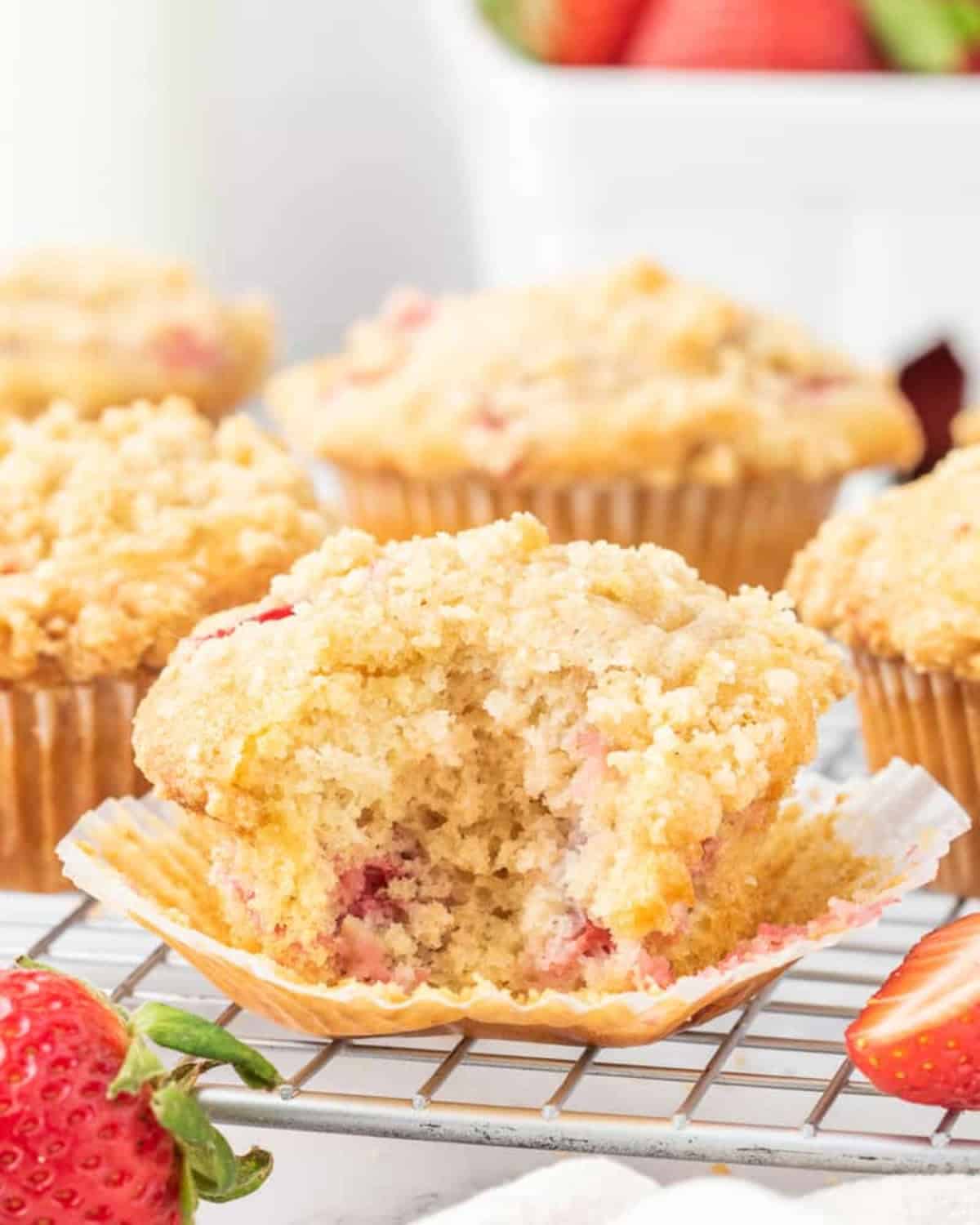 Unwrapped strawberry muffin with a bite taken out.