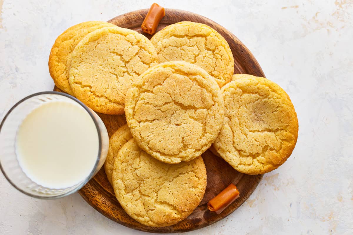 Caramel snickerdoodle cookies on a plate with a glass of milk.