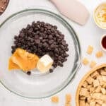 Chocolate chips, peanut butter, and butter in a mixing bowl.
