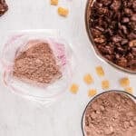 Brownie mix in a resealable bag, next to a large bowl of chocolate-coated chex cereal.