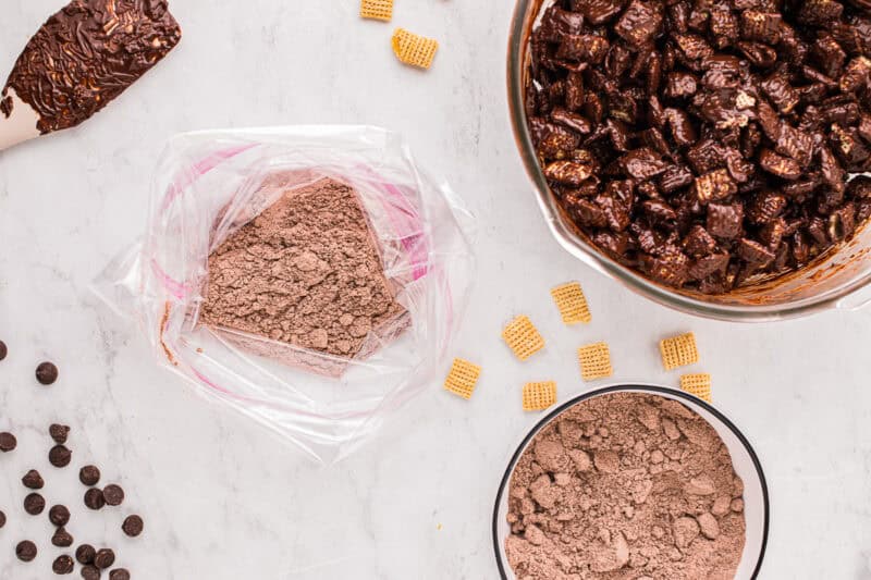 Brownie mix in a resealable bag, next to a large bowl of chocolate-coated chex cereal.